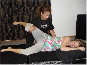 A Madriella student demonstrates how to assist a monther with stretching when she is in the side lying position