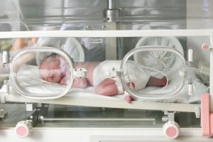 newborn baby inside incubator in hospital