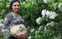 Photograph of a pregnant woman enjoying being outside in the spring.